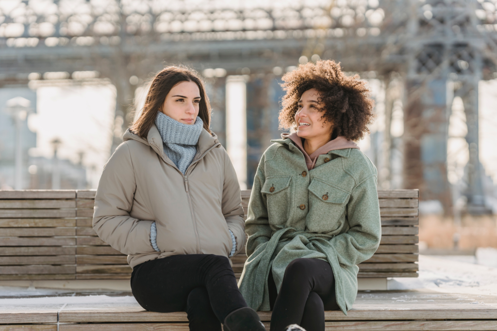 Two women with jackets talking